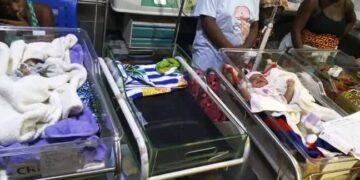 Hospital bassinets with newborn babies as health workers look on at Zwedru medical facility.