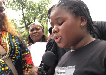 A young Liberian girl reads a petition during a protest in Monrovia calling on the UN to intervene in rising sexual violence cases.