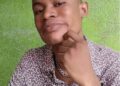 A young man identified as J. Christian Kargbo Jr., also known as MC J Christ, posing for a photo against a green wall before his arrest in a Bong County rape case