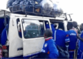 Members of Liberia’s amputee football team boarding a crowded commercial bus with luggage tied on the roof after returning from a tournament.