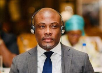 Rep. Taa Z. K. Wongbe seated at a conference wearing headphones and a suit during an ECOWAS Parliamentary session