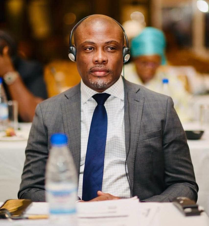 Rep. Taa Z. K. Wongbe seated at a conference wearing headphones and a suit during an ECOWAS Parliamentary session