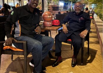 Jake Kabakole of Vision Basketball Liberia and Opeyemi Babalola of Webber Hoops & Courts seated outdoors during a pre-signing meeting in Monrovia