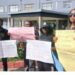LINA employees hold protest placards outside the Legislature, calling for an audit and highlighting the lack of laptops, internet, and basic tools at the state news agency.