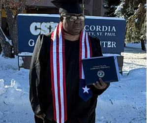Charles Paul Vah II poses with his MBA diploma after graduating from Concordia University in St. Paul, Minnesota.