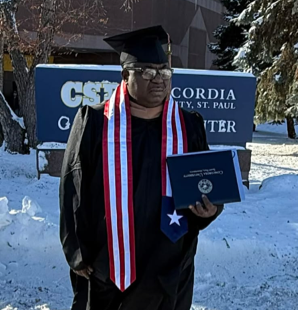 Charles Paul Vah II poses with his MBA diploma after graduating from Concordia University in St. Paul, Minnesota.