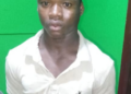 A suspect stands at a police station in Margibi County following an arrest in a child kidnapping investigation.