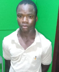 A suspect stands at a police station in Margibi County following an arrest in a child kidnapping investigation.