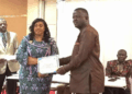 Nimba County education officials present certificate to newly added volunteer teacher during payroll induction ceremony.