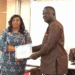 Nimba County education officials present certificate to newly added volunteer teacher during payroll induction ceremony.