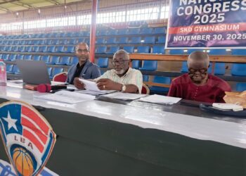 Liberia Basketball Association officials seated at the 2025 policy congress at SKD Gymnasium reviewing documents during the session.