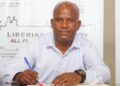 Wubetu Abate seated at a desk signing his contract as the new head coach of LISCR FC