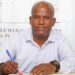 Wubetu Abate seated at a desk signing his contract as the new head coach of LISCR FC
