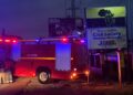 Liberia National Fire Service truck parked at night beside the STAND civil society headquarters sign in Monrovia after a suspected arson attack