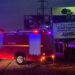 Liberia National Fire Service truck parked at night beside the STAND civil society headquarters sign in Monrovia after a suspected arson attack