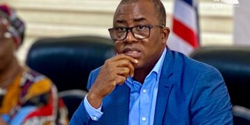 Former LTA Chair Abdullai Kamara seated in a courtroom setting during legal proceedings, appearing thoughtful as corruption charges against him advance to Buchanan
