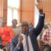 Senator Amara Konneh raises his hand during a legislative session as he questions the legality of FY2026 budget transfers and calls for stronger Senate oversight.