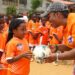 LFA official hands a football to a young girl during the launch of a girls’ football development campaign in Paynesville.