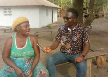 TLI reporter Rancy Clarke interviewing a woman in Sawolor Town for the story that won him the 2025 Young Journalist of the Year Award.