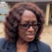 A woman speaking to the media outside a public building in Monrovia following a procurement dispute involving the NEC.