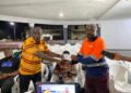 ArcelorMittal Liberia representative presents a donation cheque to county officials in support of the National County Sports Meet.
