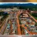 Graphic showing ArcelorMittal mining site aerial view, AML workers, company logo and Liberia Senate chamber after deal approval
