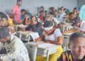 University of Liberia applicants seated in a crowded classroom writing the entrance examination in Monrovia.