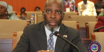 Representative Jeremiah G. Sokan speaking into a microphone during a legislative session at Liberia’s House of Representatives