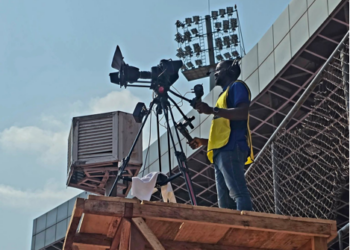Camera operator films live sports broadcast for Intel Sports in Liberia