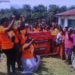 Group of women wearing orange shirts gathered outdoors holding a banner during a Women’s Land Rights Taskforce awareness event