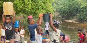 Residents of Morris Farm Community in Todee District, Rural Montserrado County, fetch water and wash clothes at a creek along the Du River due to limited access to hand pumps.