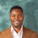 Cassell Kouh in brown jacket smiling