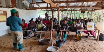 Trainer Jacob B. Dennis instructs youth trainees during a hands-on agriculture session at the Youth International Training Institute farm near Gbarnga.
