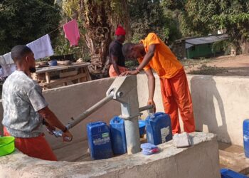 inmates fetching water at the community water pump