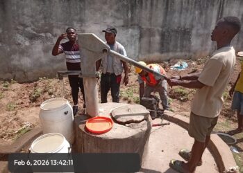 Workers repair a hand pump at Gbarnga Central Prison in Bong County