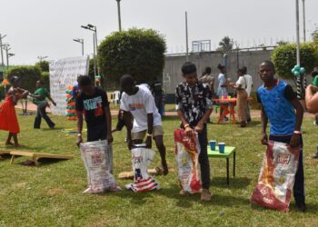 Children participate in sack races and learning games during KEEP Liberia’s PlayFest, a literacy-focused family event in Monrovia.