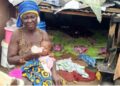 Elderly woman and baby left homeless after demolition in Saye Town, Liberia.