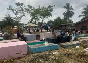 Families cleaning and decorating graves during Decoration Day in Liberia.
