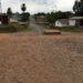 Unpaved road with dust and nearby homes in a Liberian community