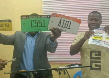 Officials display new Liberian vehicle license plates during the transition of licensing services to Liberia Traffic Management Inc.