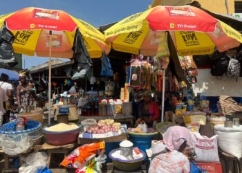 Market women selling goods inside a busy market hall in Monrovia, Liberia.