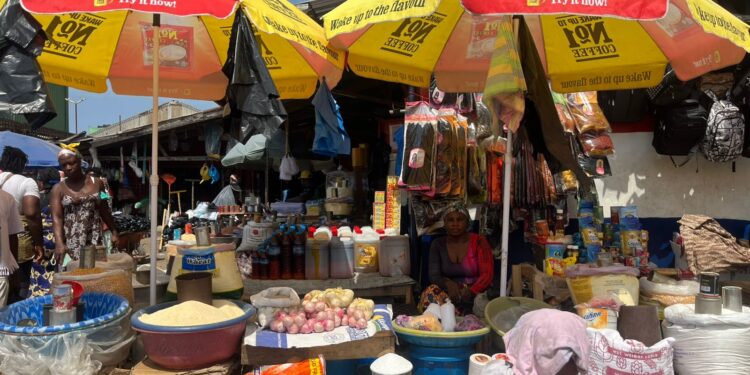 Market women selling goods inside a busy market hall in Monrovia, Liberia.