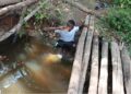 Child fetching water from contaminated creek in Kuyon Town, Bong County, highlighting Liberia’s rural water crisis