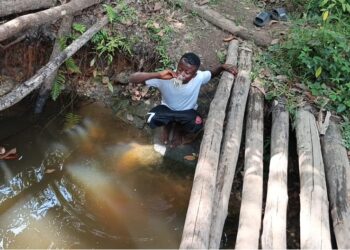 Child fetching water from contaminated creek in Kuyon Town, Bong County, highlighting Liberia’s rural water crisis