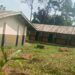 Dilapidated classrooms at Suasu Public School with damaged roof and overgrown compound