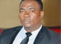 A Liberian rights defender dressed in a black suit and tie attends a public event in Monrovia.
