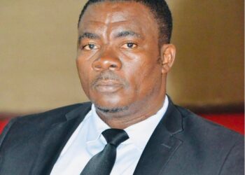 A Liberian rights defender dressed in a black suit and tie attends a public event in Monrovia.