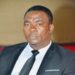 A Liberian rights defender dressed in a black suit and tie attends a public event in Monrovia.