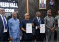 Liberian officials display signed partnership documents for a new vehicle insurance credit program for civil servants in Monrovia