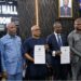 Liberian officials display signed partnership documents for a new vehicle insurance credit program for civil servants in Monrovia